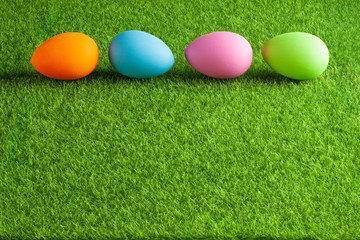 Four colored Easter eggs on grass