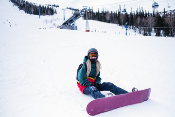 Fototapeta na wymiar Girl with a snowboard on a snowy slope.