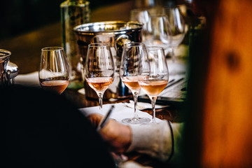 A glass of rose wine at a table tasting.