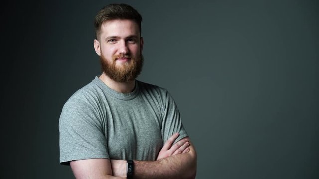 Half length portrait of young bearded hipster man smiling at camera