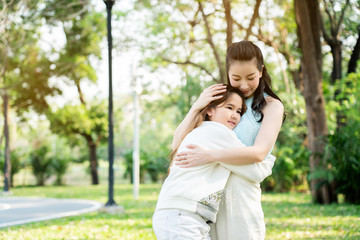 Asian mother and daughter stood hugging each other with a smile, love that was given to each other in the garden. The long weekend of summer. International Women's Day and Mother's Day in May.