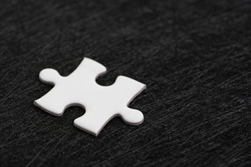 Closed up of white jigsaw puzzle on dark black background using as answer, solution, completion or strategy for business success