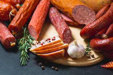 Different types of sausages and meat products on a black background.
