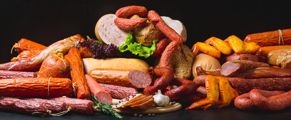 Different types of sausages and meat products on a black background.