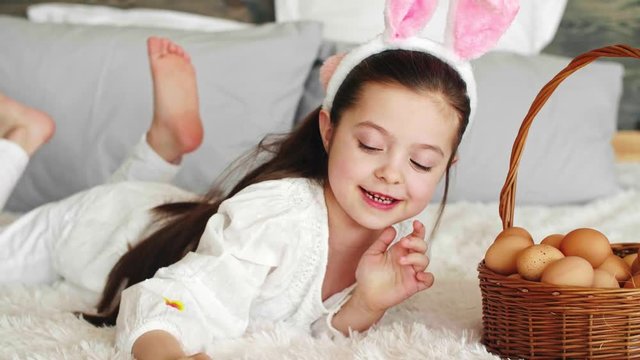Playful girl putting eggs in the easter basket