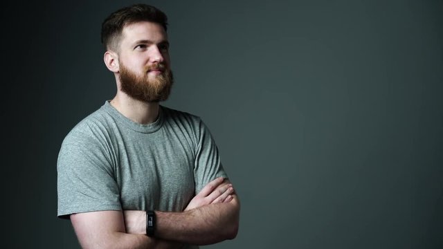 Half length portrait of young bearded hipster man looking at blank copy space
