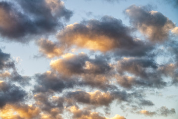 Naklejka na ściany i meble Yellowish clouds against blue sunset sky