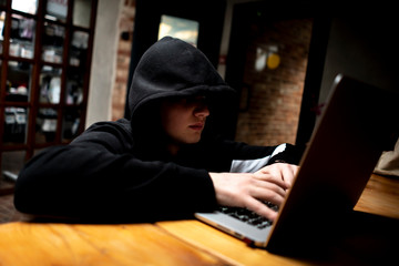 male hacker using laptop, breaking the government servers with personal data f