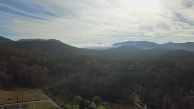 209 Aerial panning 270 degrees revealing mountain houses and lake Autumn