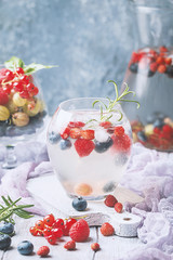 Detox fruit infused flavored water with ice. Refreshing summer homemade cocktail with berries
