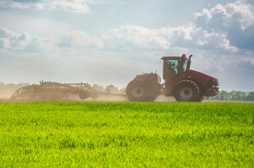 Tractor cultivating field at spring