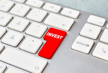 Investing online concept with keyboard and red key