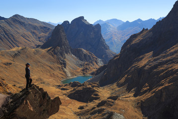 Naklejka premium Woman looking at a valley and mountains on a clear, autumn day.