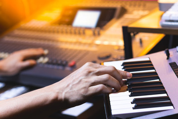 composer, producer hands playing keyboard for recording midi track in home studio. music production...