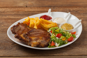 Grilled pork neck served with French fries and salad.