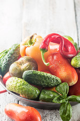 Fresh organic vegetables from the garden in metal pan over rustic wooden background