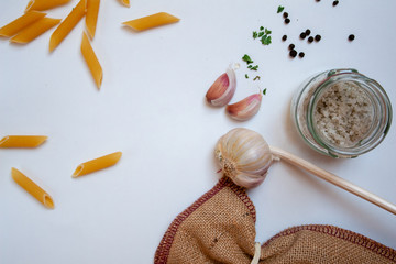 Pasta, garlic and salt on a white board background