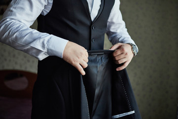 Businessman wears a jacket,male hands closeup,groom getting ready in the morning before wedding...