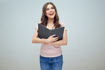 smiling girl holding open book in front of him.