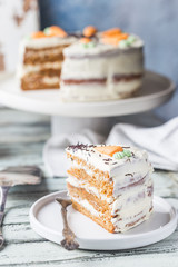 Healthy homemade carrot cake with cream cheese frosting on white wooden table