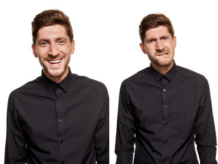 Handsome man in a black shirt makes faces, standing against a white background