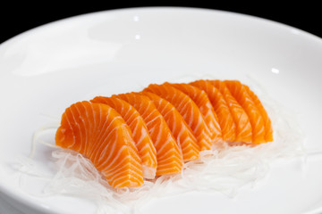 salmon sashimi, raw on a plate on a white background