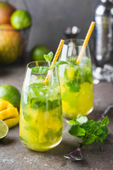 Fresh mango mojito cocktail with lime and mint in a glass