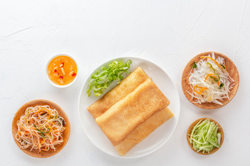 Traditional Chinese tortillas filled with bings in a plate on a white background, hot salads, Dam Sam snacks. View from above. Copy space
