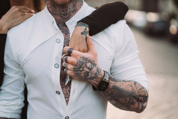 A man holds a woman's hand on his torso