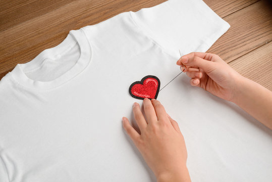 Woman Sewing A Heart Patch