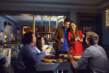 Friends congratulate a couple at a restaurant dinner