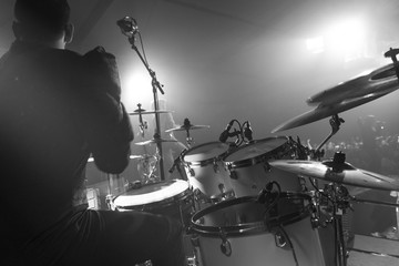 Monochrome drummer with drumset from behind