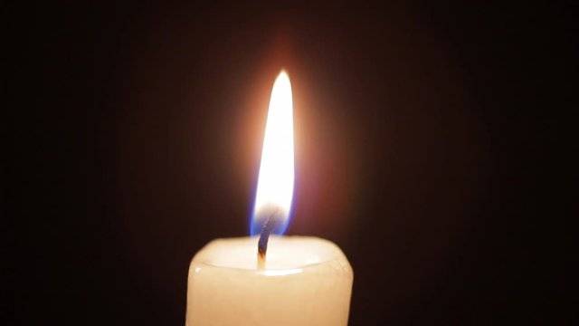 Burning Candle In Dark. Close Up Man Hand Lighting Candle With Match On Black Background