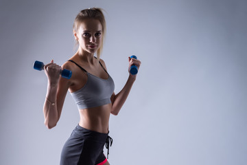 young woman with dumbbell on white background