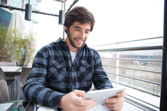 Joyful guy using gadget for chatting