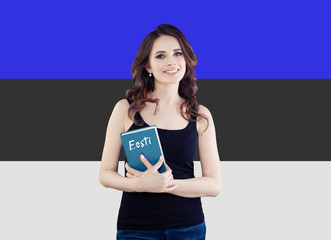 Portrait of beautiful woman student with book against the Estonia flag background. Learn estonian language concept