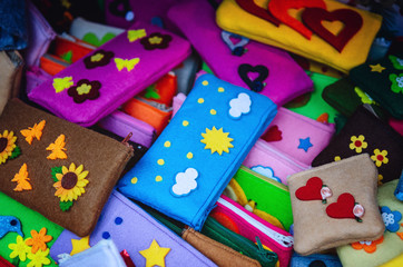 many felt handmade pencil cases for children's school, with flowers, clouds and heart shaped decorations 