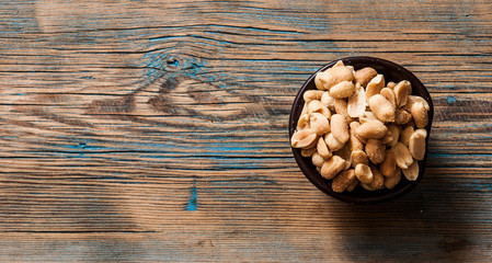 Obraz na płótnie Canvas Roasted, salted peanuts are placed on a wooden background