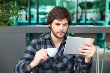 Serious young entrepreneur checking up business news