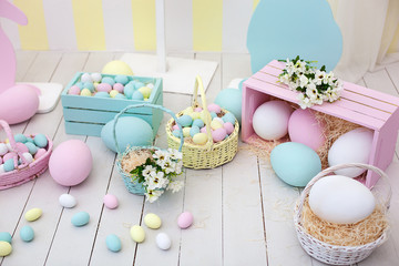 Easter! Many colorful Easter eggs with bunnies and baskets of flowers! Easter room decoration and decor, children's playroom. Colorful large and small painted Easter eggs and colorful rabbits.