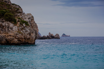 Fototapeta na wymiar Paleokastritsa bay cliffs with Kolyviri island on a rainy day