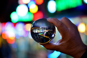 Fototapeta premium hand holding lens ball on bokeh background