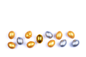 Golden and silver colored Easter eggs isolated on white background. Place for text.