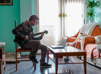 Man learn playing electric guitar at home