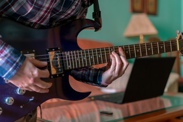 Obraz na płótnie Canvas Man learn playing electric guitar at home