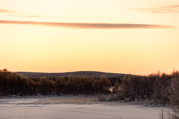 The ice lake and forest has covered with heavy snow and nice blue sky in winter season at Holiday Village Kuukiuru, Finland.
