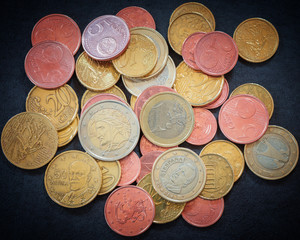 Euro coins on dark gray suede as business, money, banking, currency and exchange rate concept