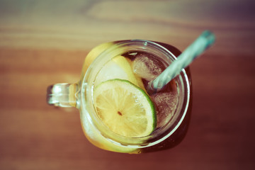 Ice tea with slices of lemon and lime in glass