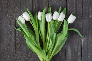 White tulips on brown black wooden background with copy space for card