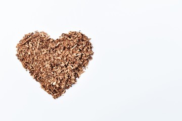 heart-shaped wood saw dust on dirty white background